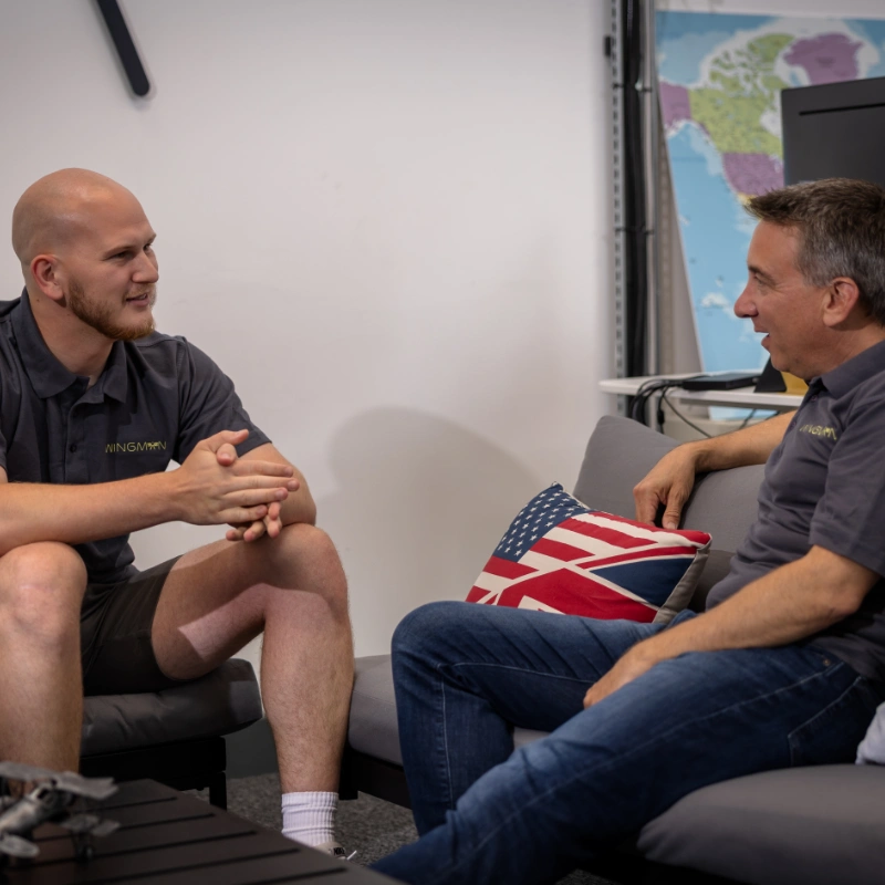 Josh and Mark sitting on sofa at Wingman office having chat
