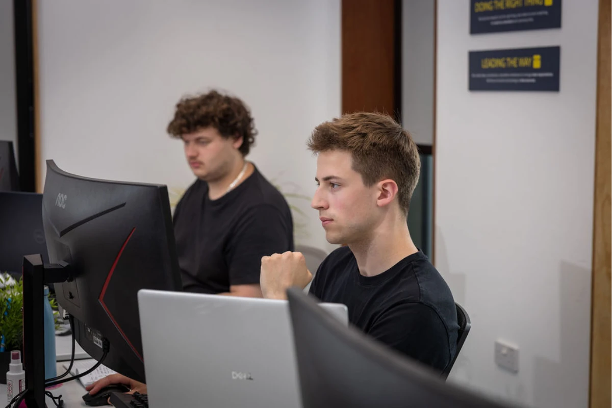 Callum and Tom sat working at their desks on latest website projects